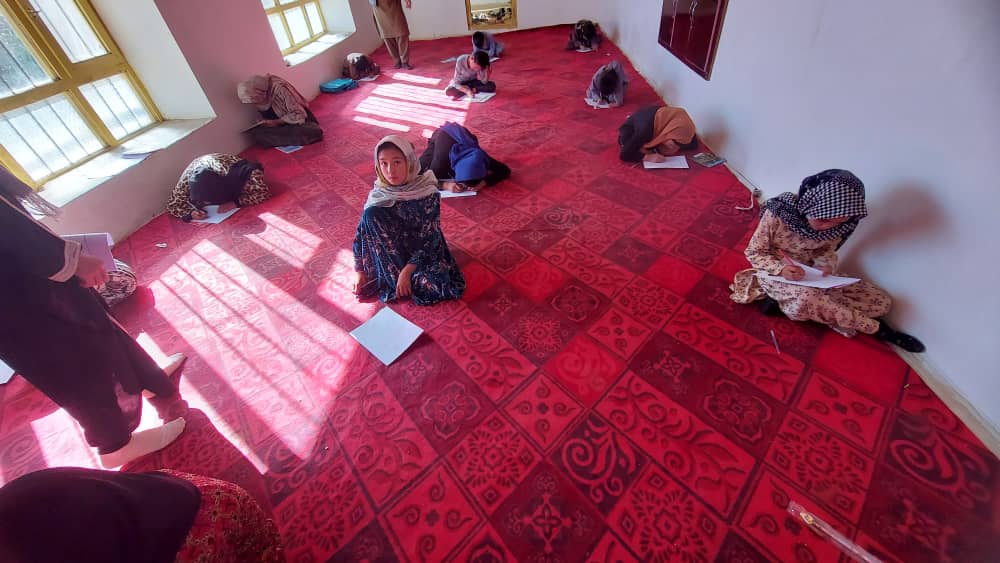 Jeune fille afghane lisant un livre en classe